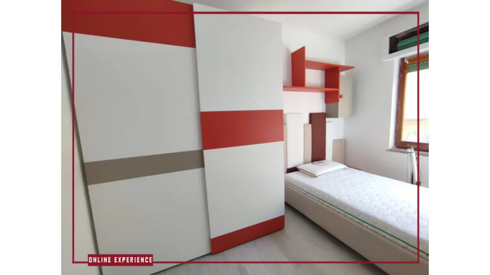 Cameretta MORETTI COMPACT composta da letto imbottito una piazza e mezza, con particolare pannellatura imbottita a muro. Comodino sospeso.  Armadio scorrevole attrezzato, scrivania sospesi con elementi libreria superiori.  Sedia imbottita abbinata al lett